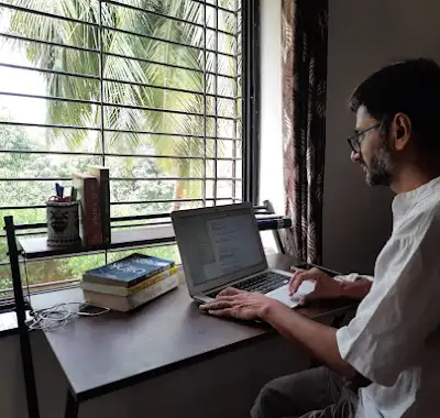 Tapan Patel writing beside a window